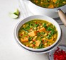 Curried kale & chickpea soup in a white bowl