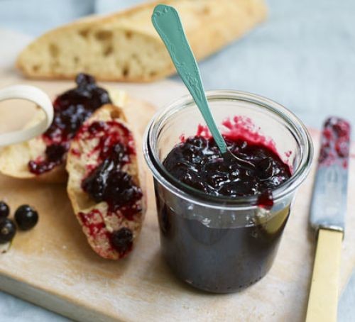 Blackcurrant jam in a jar and spread on toast
