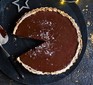 Vegan chocolate & date tart with a slice cut out