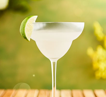 Frozen margarita with lime wedge on glass
