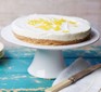 Lemon cheesecake on a stand, topped with lemon zest