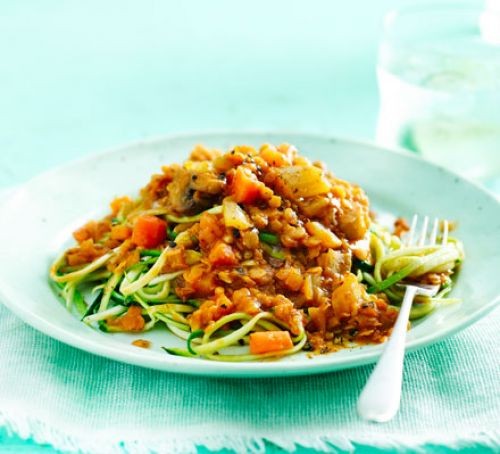 Courgetti topped with lentil ragu, served on a plate with a fork