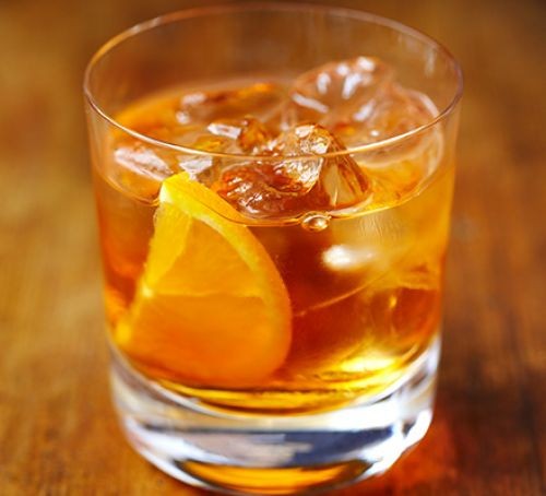 Old fashioned whisky cocktail in a glass with orange slice