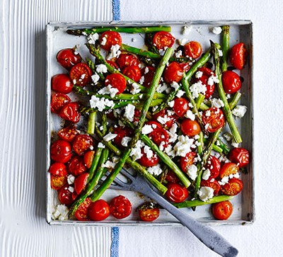 asparagus and tomatoes in pan on white table