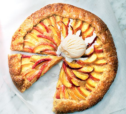Peach galette with brown sugar crust cut into slices