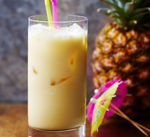 Pina Colada in glass with pineapple and cocktail umbrella