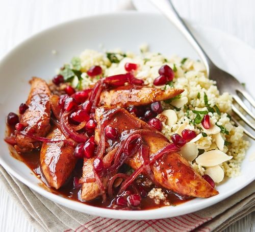 Chicken pieces in pomegranate sauce with couscous in a bowl