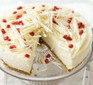 White chocolate cheesecake topped with pomegranates and white chocolate curls