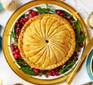 One caramelised onion, squash & spinach pithivier on a decorative plate