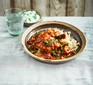 Bowl of chicken curry and rice next to a bowl of yoghurt and glass of water