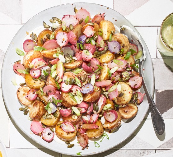 New potatoes and radish salad on a large plate served with a big spoon