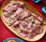 Pepper-crusted roast beef with béarnaise butter served on a platter