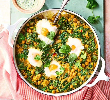 Dhal poached eggs with herbs in a frying pan