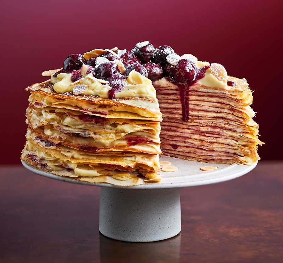 One cherry bakewell crêpe cake on a stand