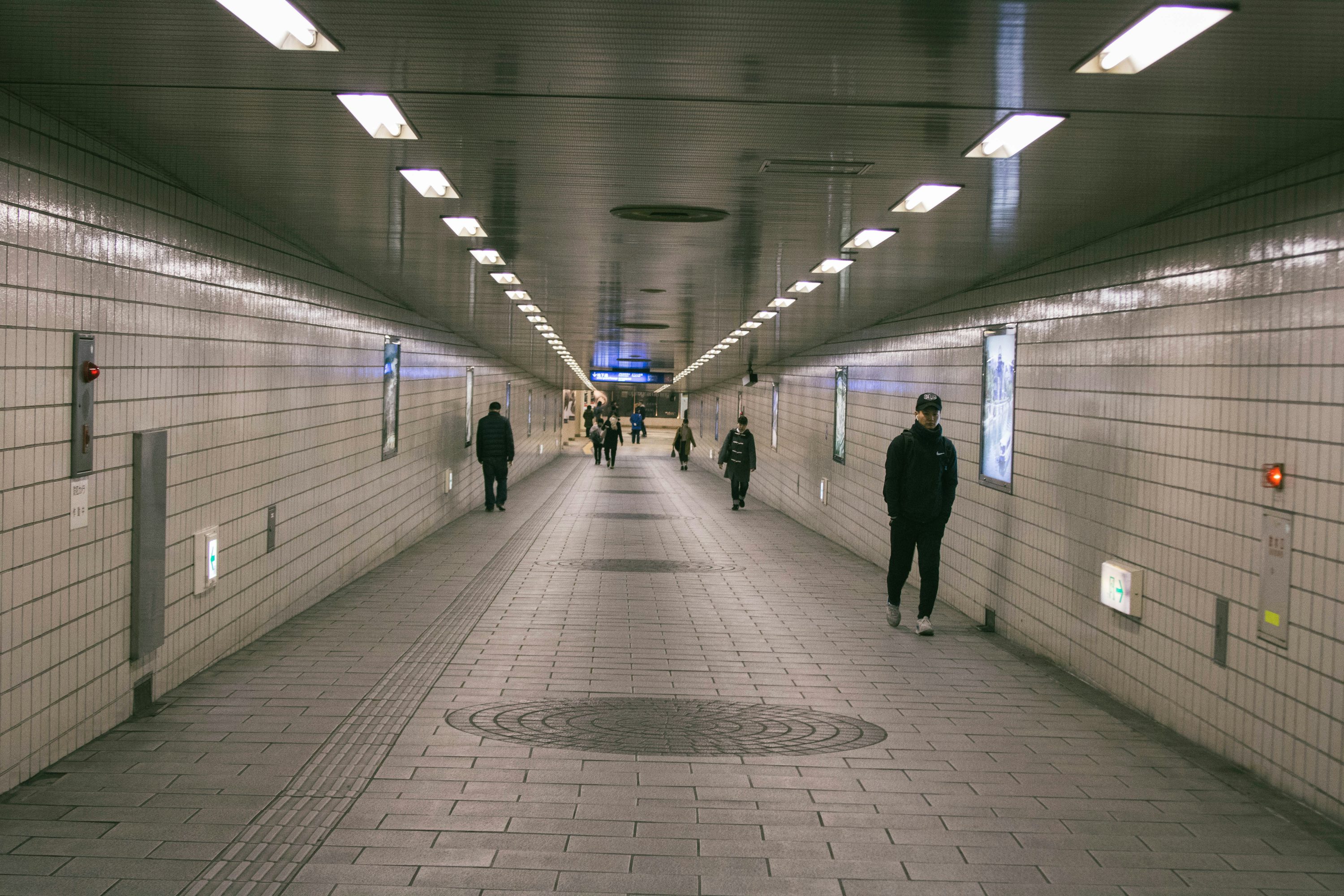 personnes marchant sous le métro