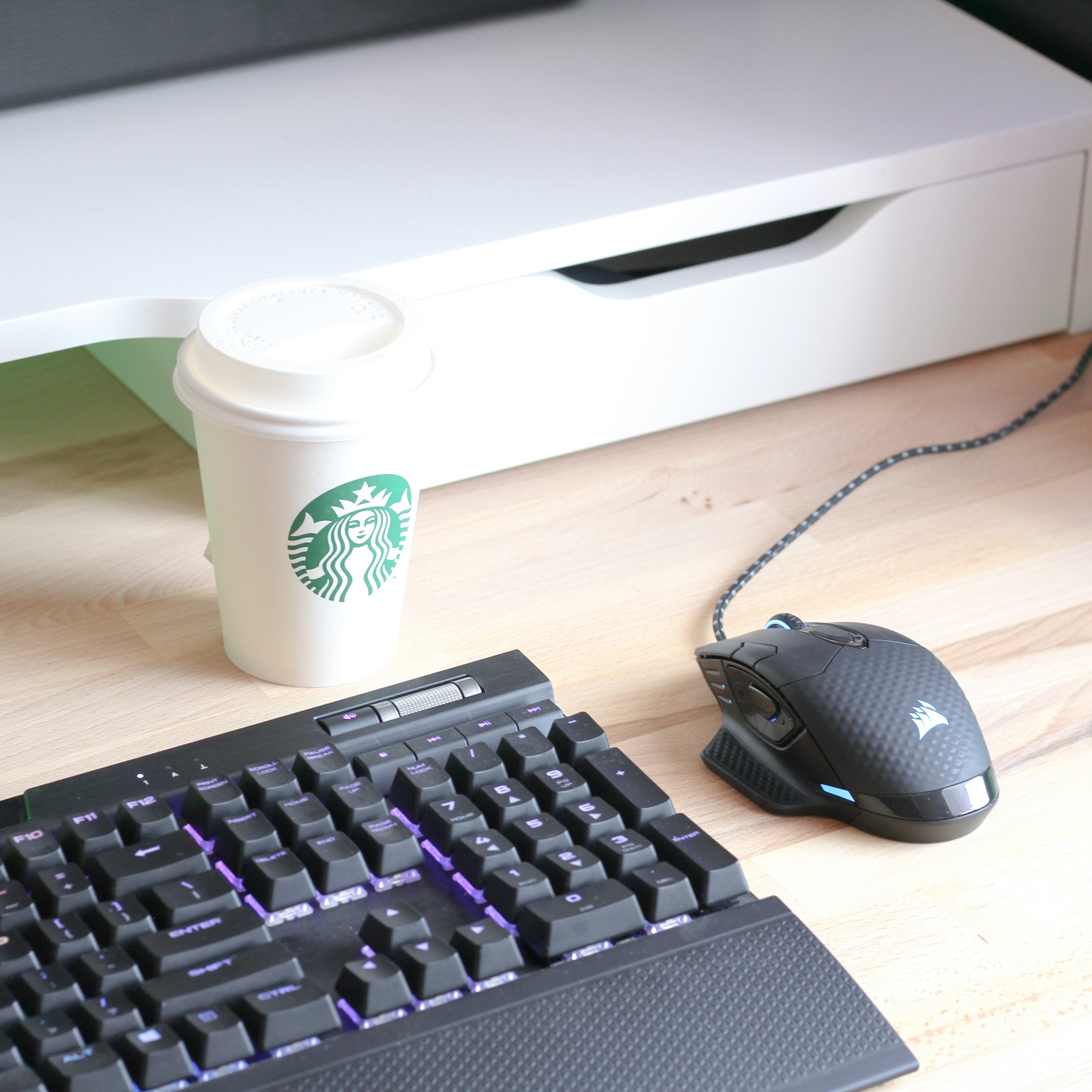 clavier d’ordinateur noir à côté d’un gobelet jetable blanc et vert