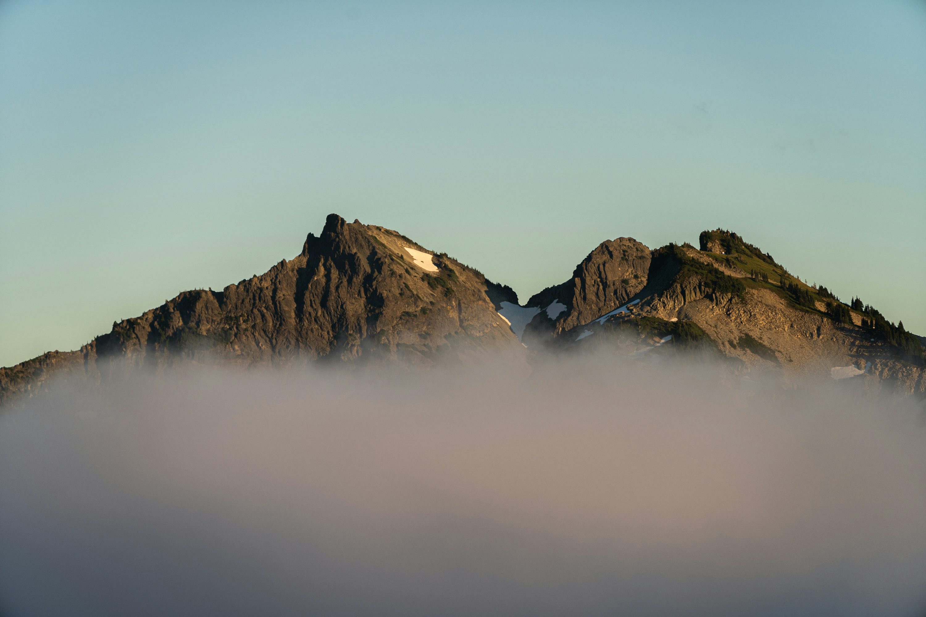 Montaña rocosa marrón bajo el cielo blanco durante el día