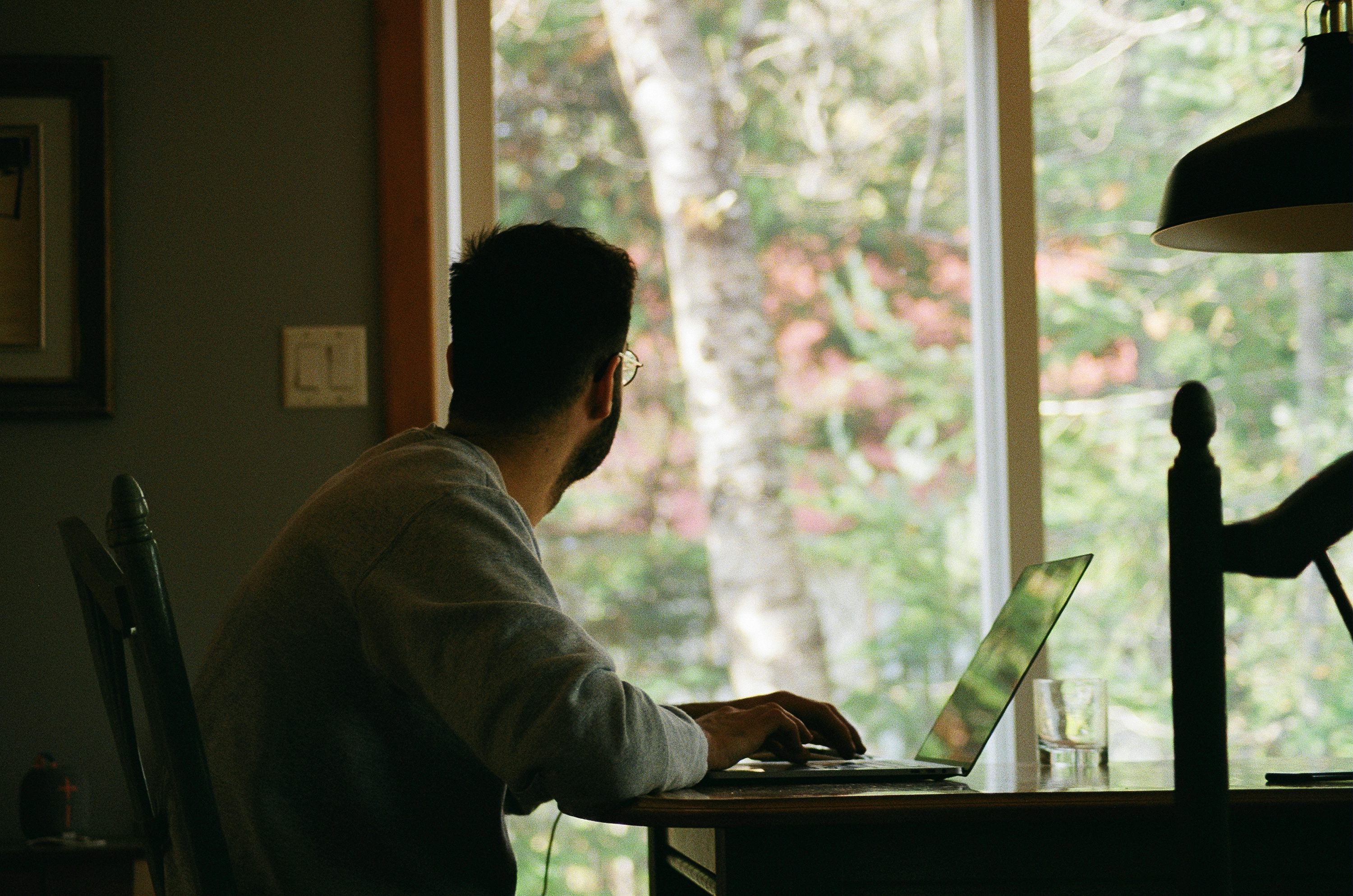 hombre con sudadera con capucha gris usando computadora portátil