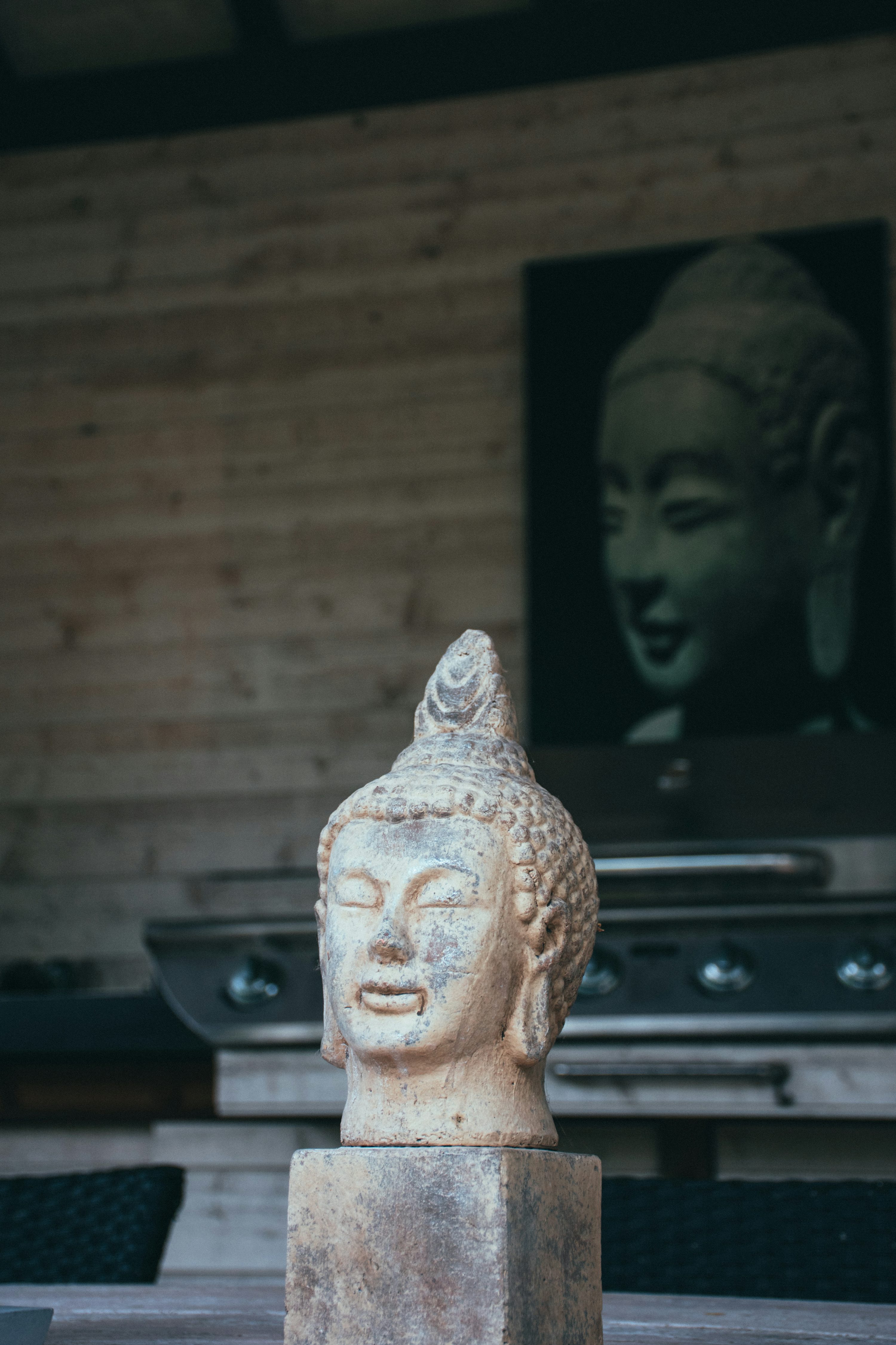 Figura de Buda de cerámica marrón sobre mesa negra