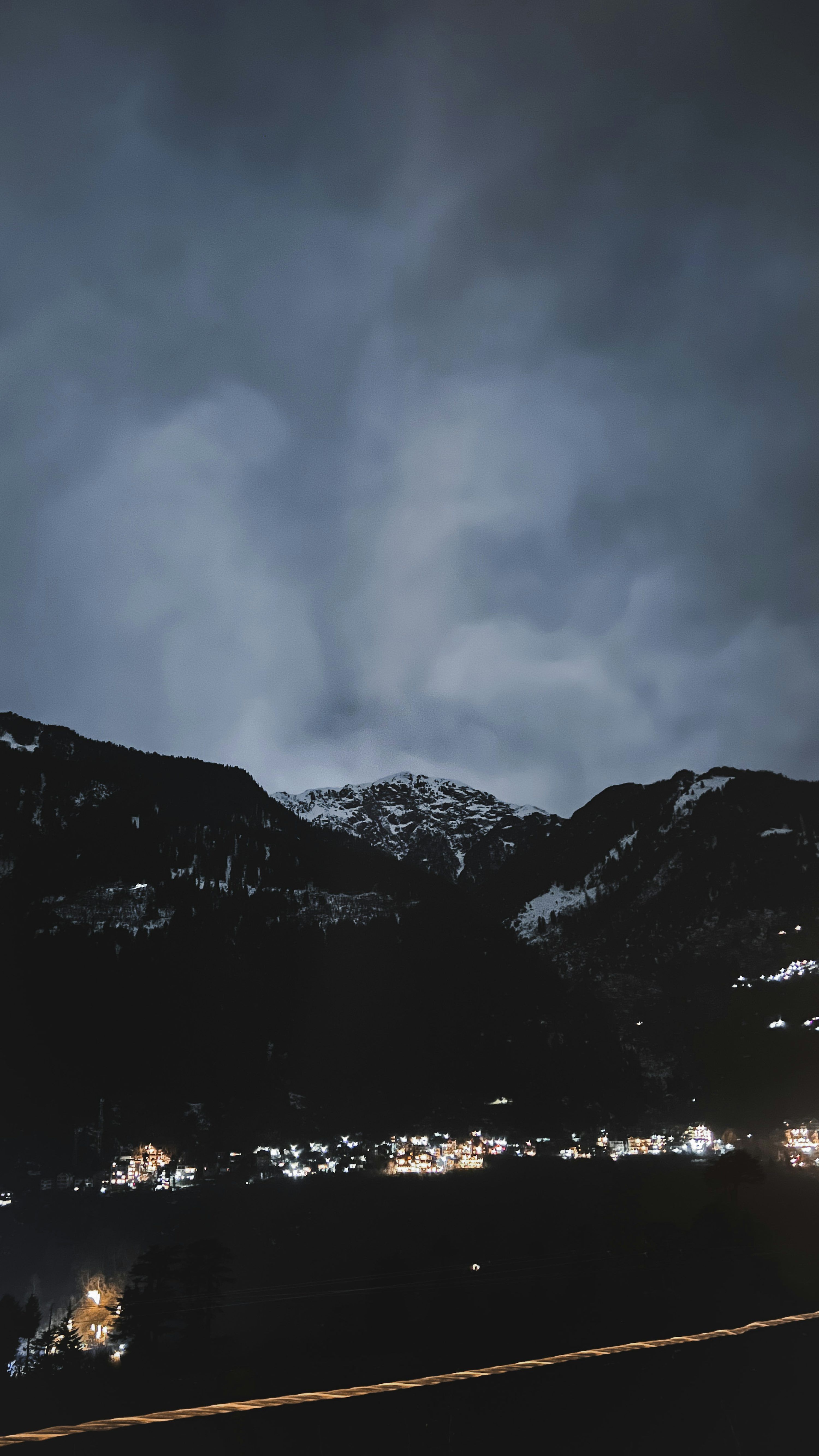 Una montaña cubierta de nieve por la noche con un cielo nublado