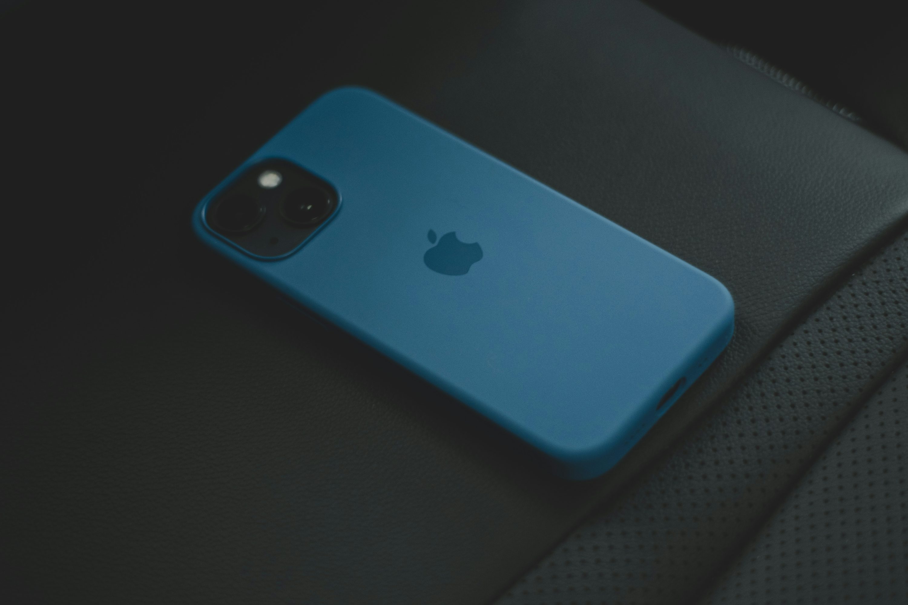 Un iPhone azul sentado encima de un asiento de coche