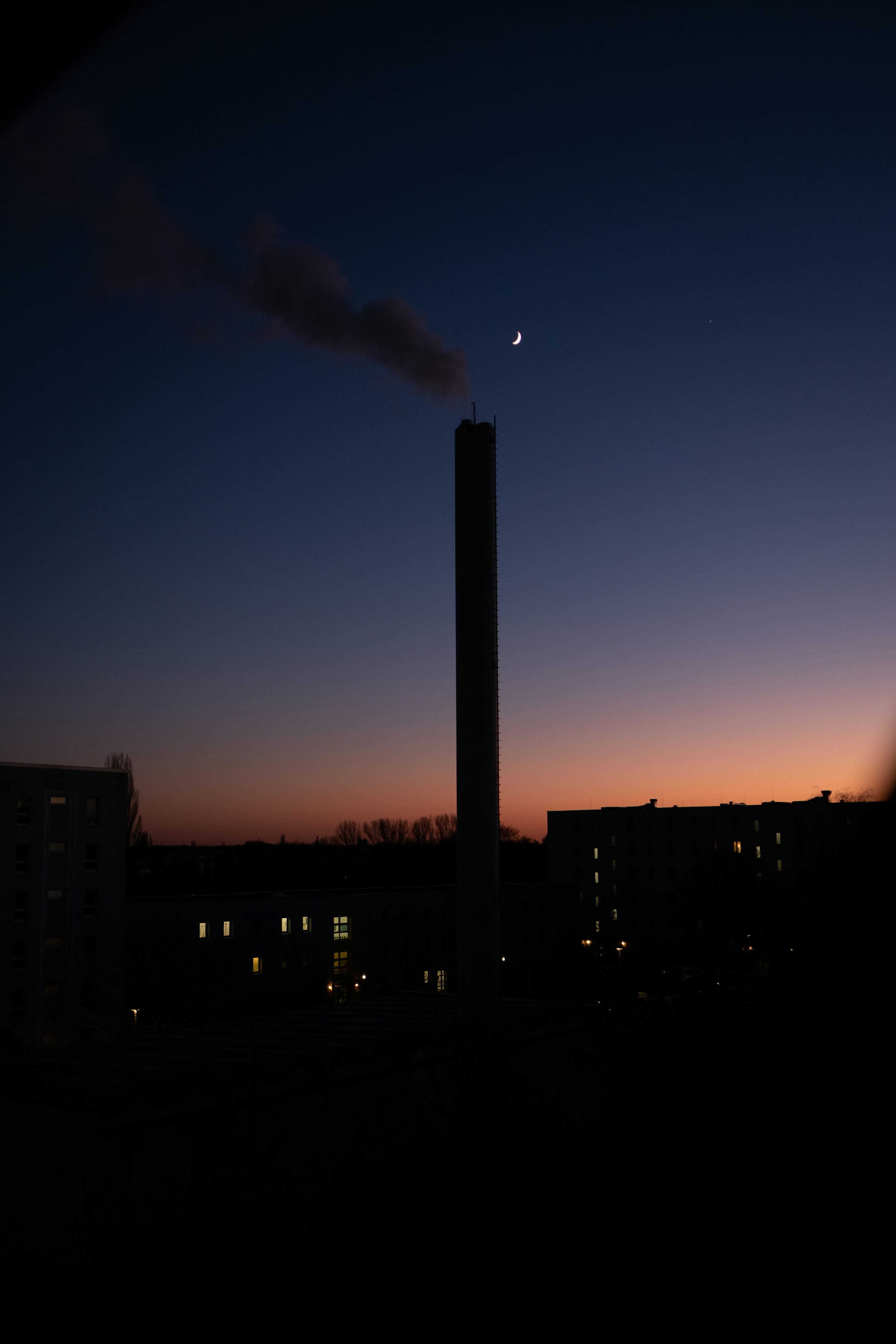 Una chimenea emite desde un edificio por la noche