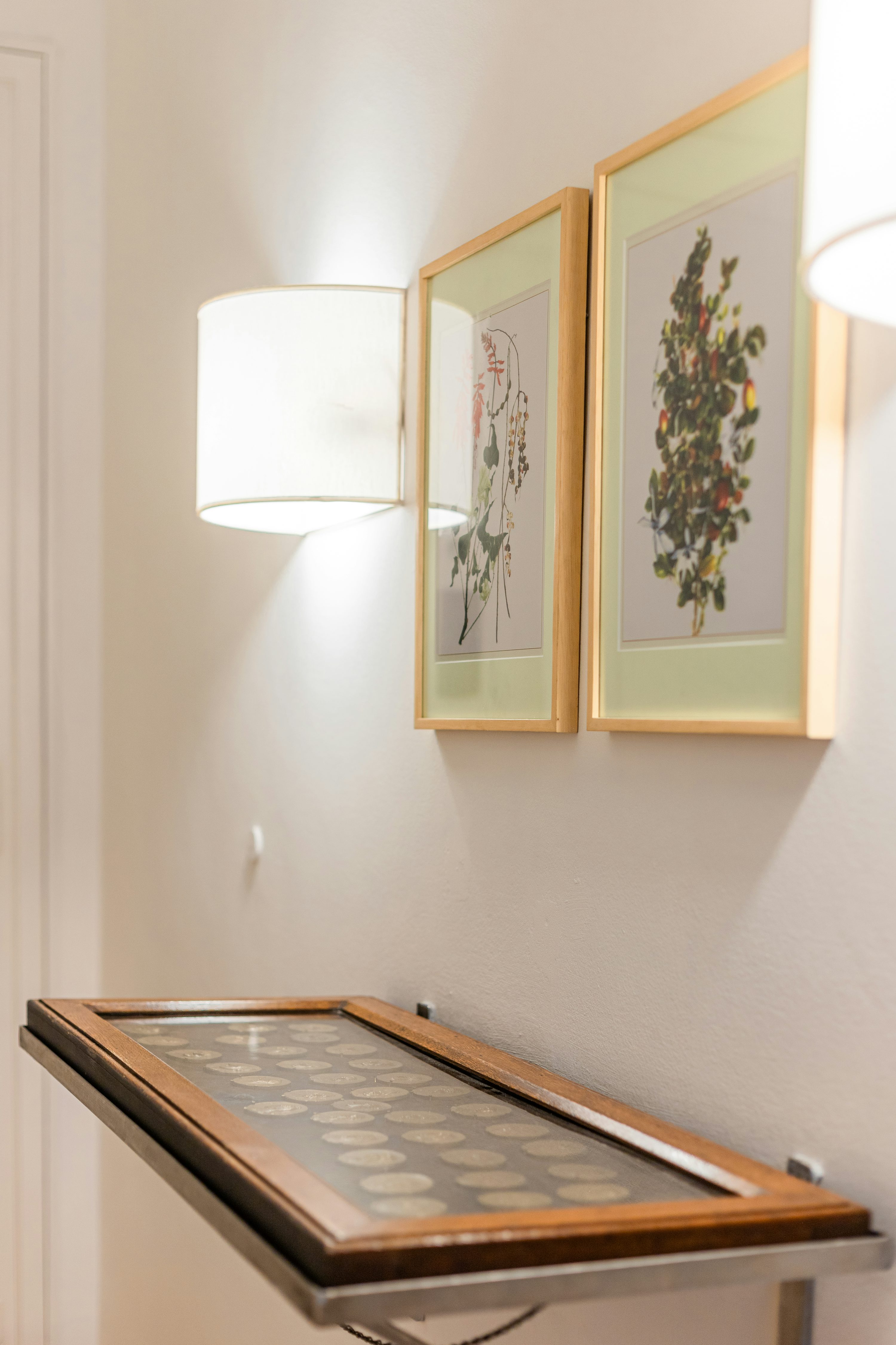 una mesa con una lámpara y cuadros en la pared