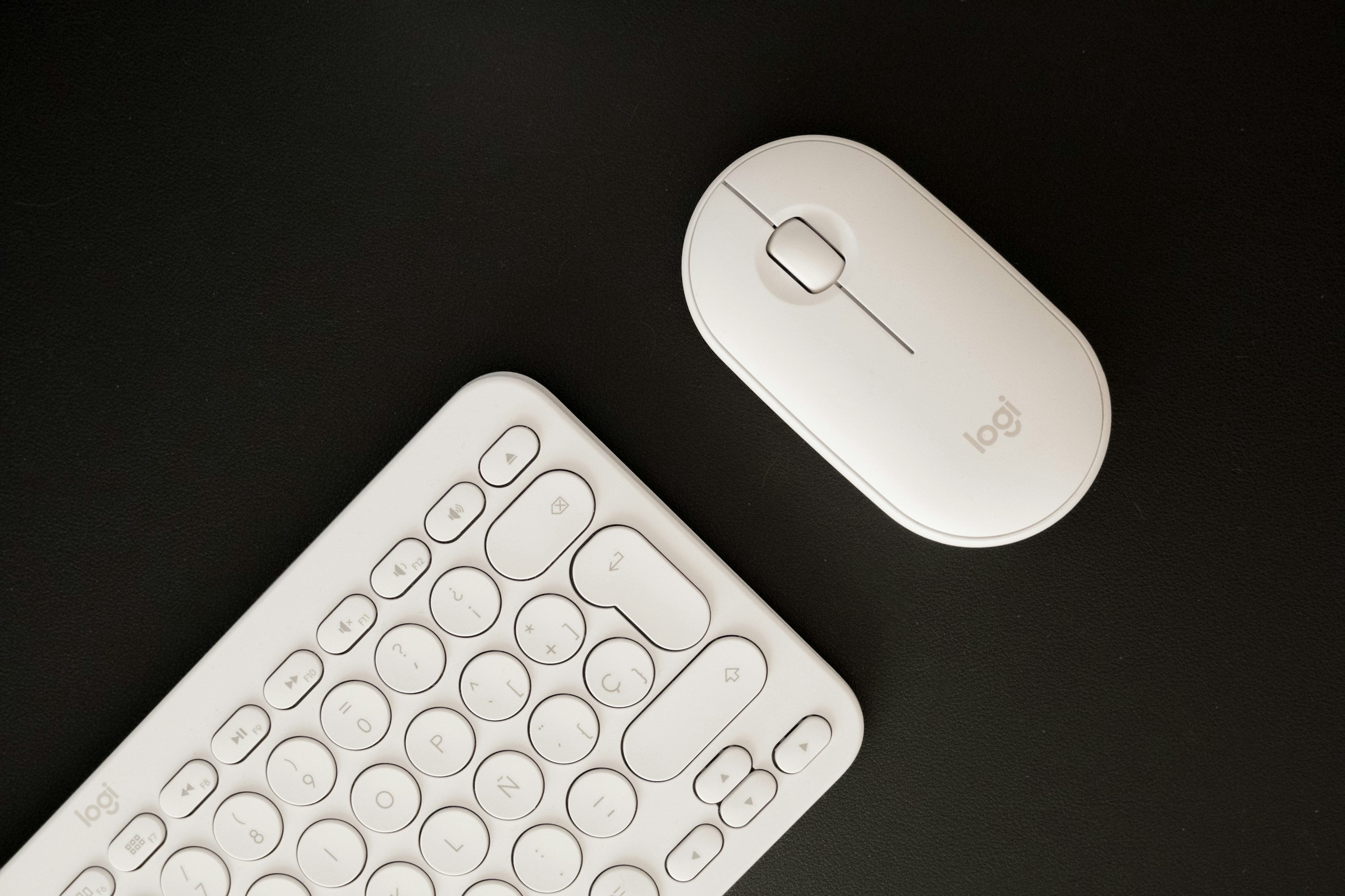 un teclado y un ratón sobre una superficie negra