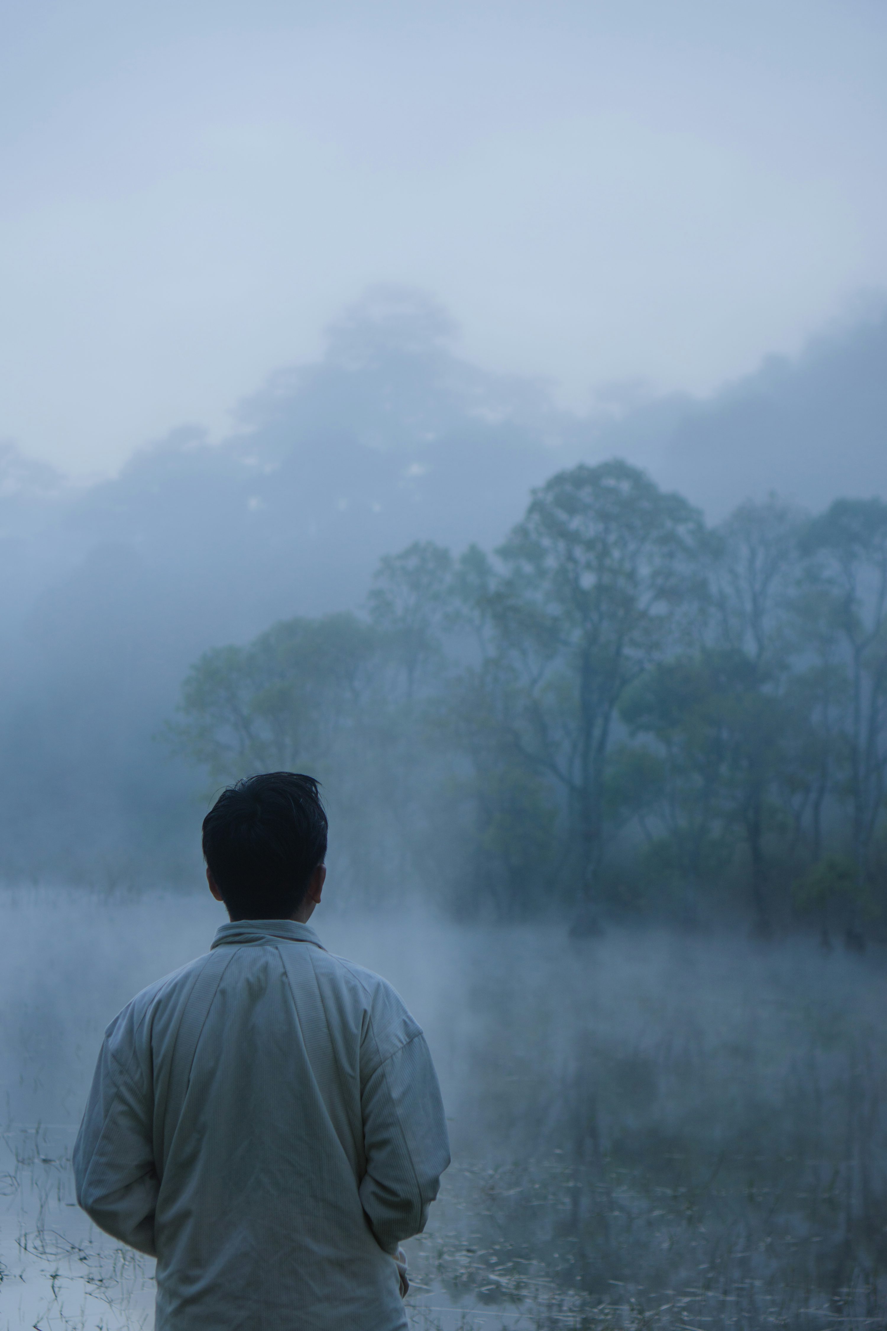 un homme debout devant un champ brumeux