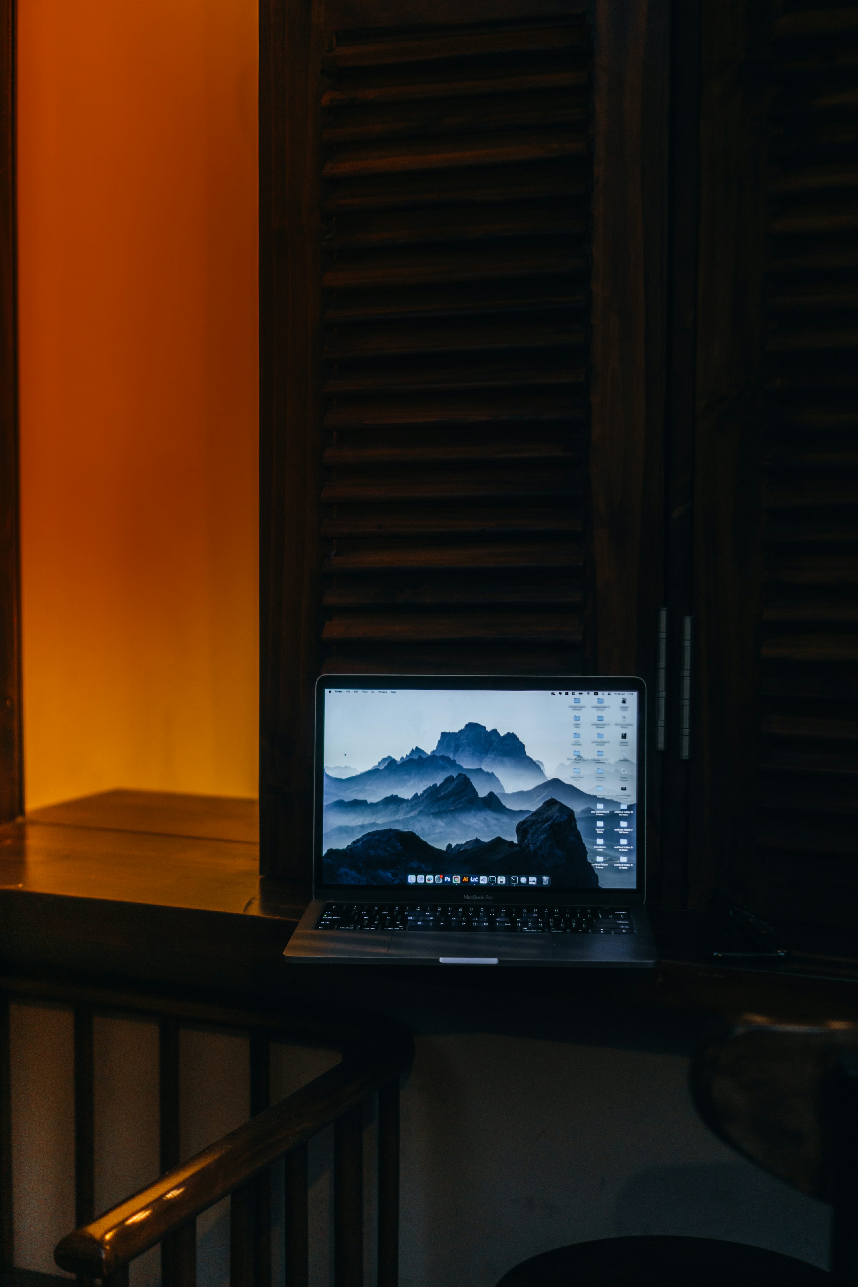 un ordinateur portable posé sur un bureau en bois