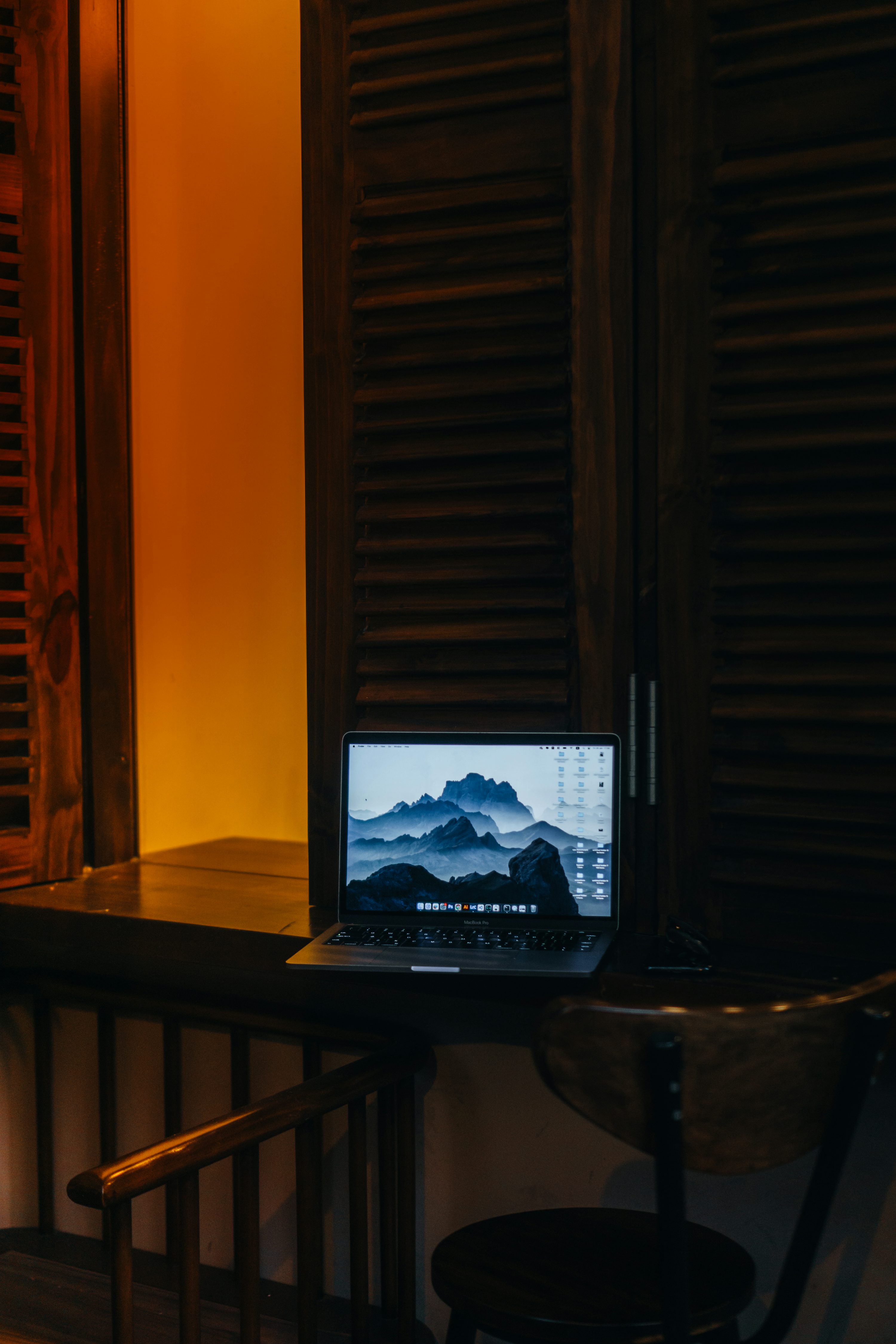 un ordinateur portable posé sur un bureau en bois