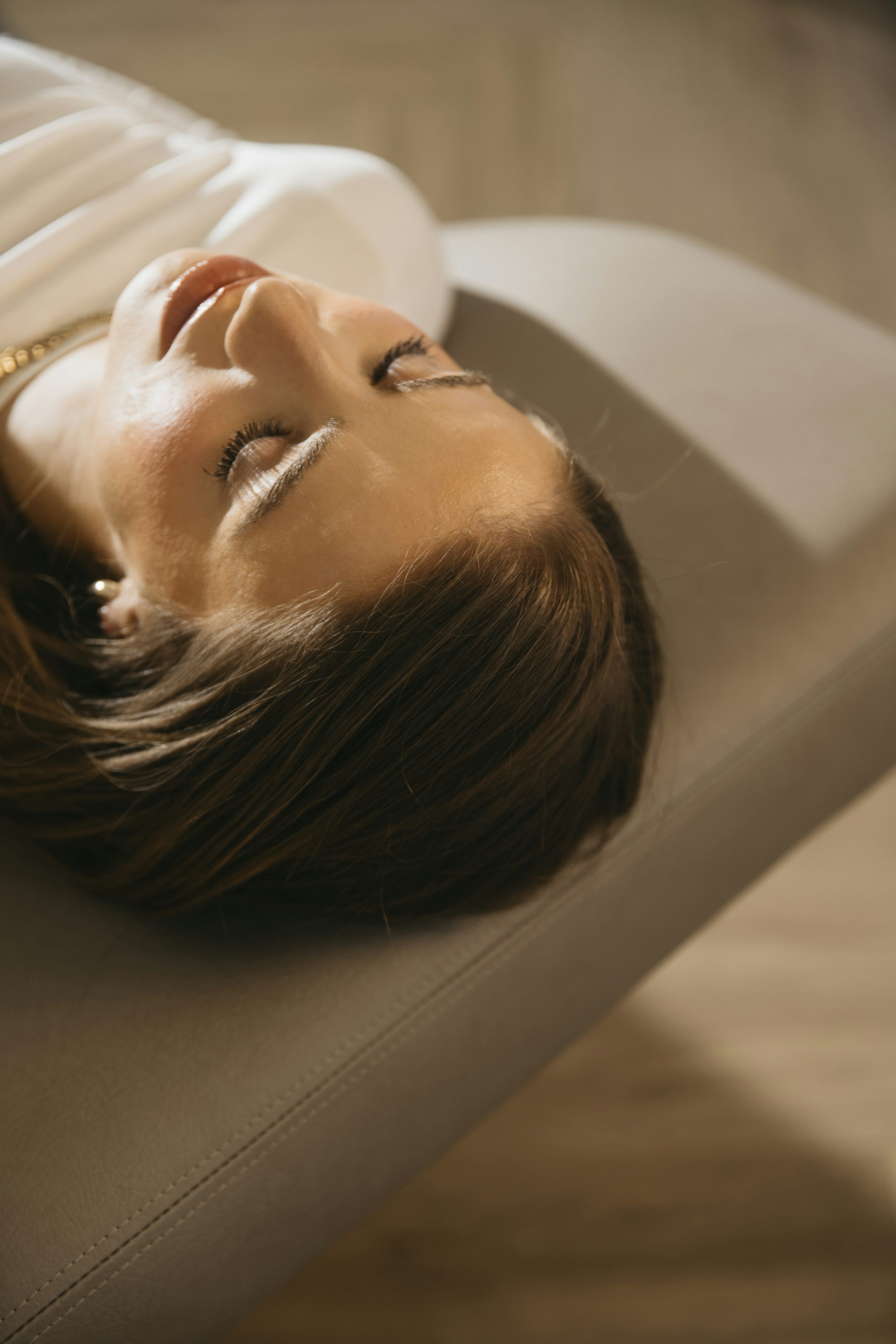 a woman laying on a couch with her eyes closed