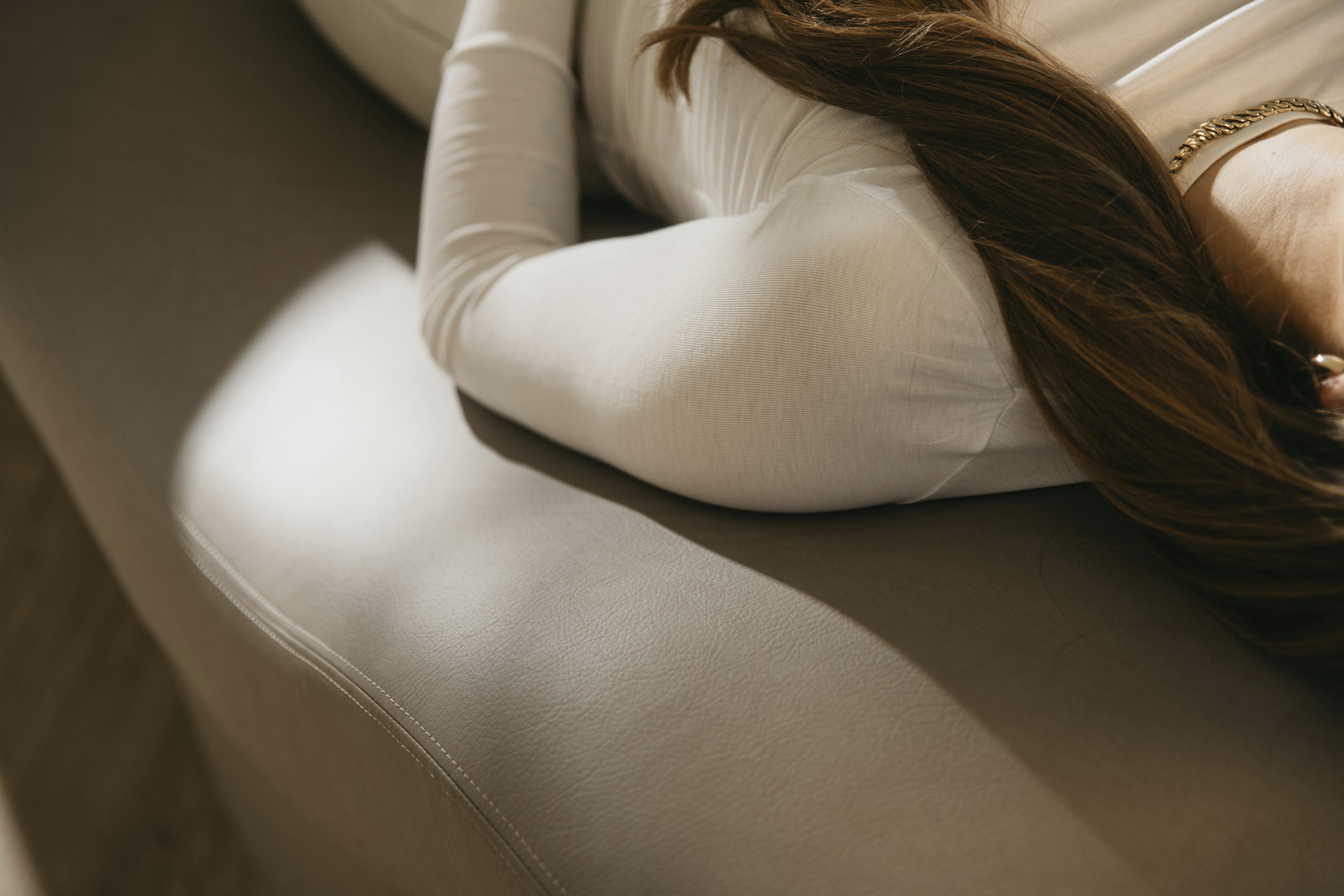 eine Frau mit langen Haaren liegt auf einer Couch