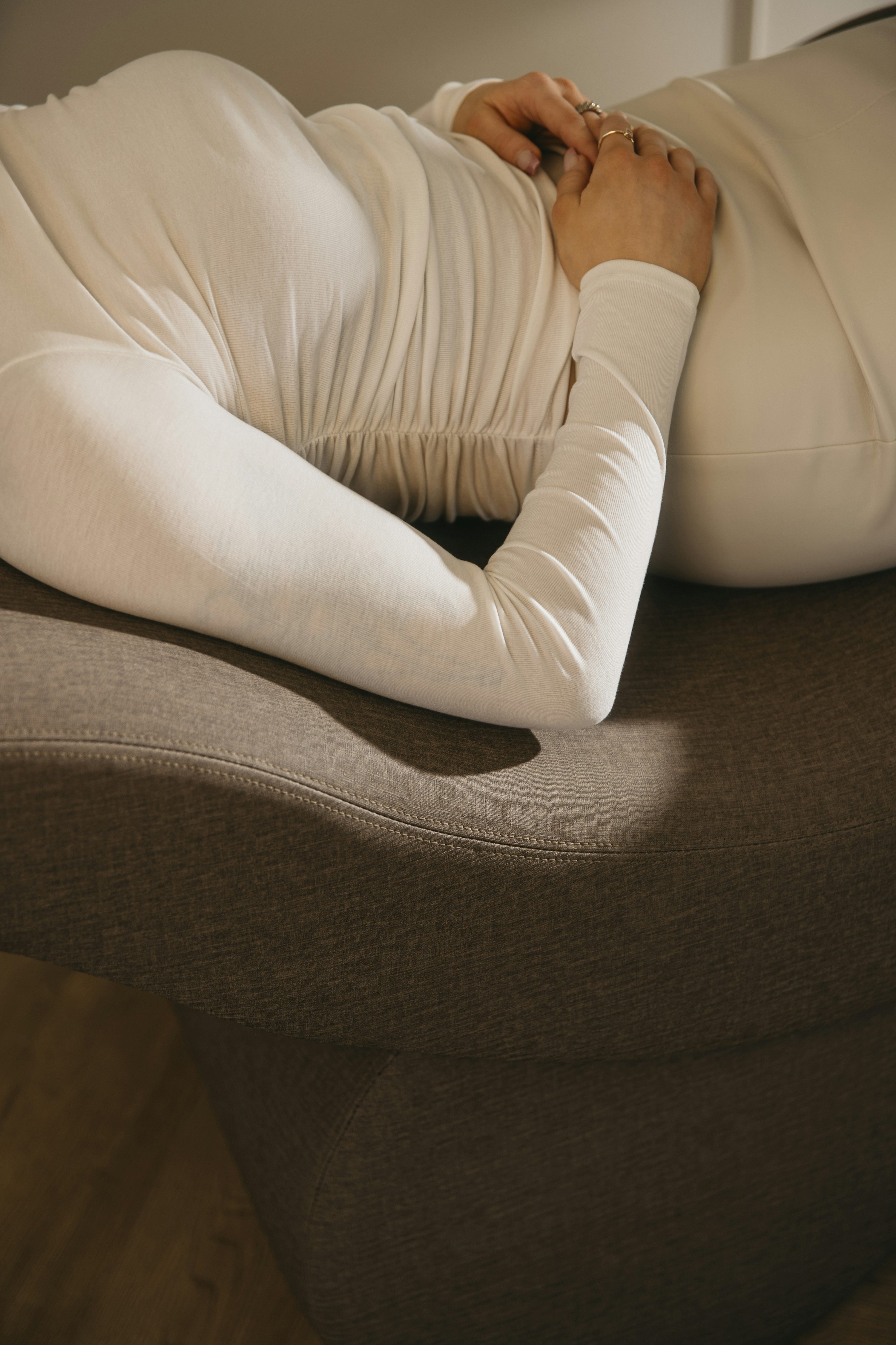 a woman laying on top of a brown couch