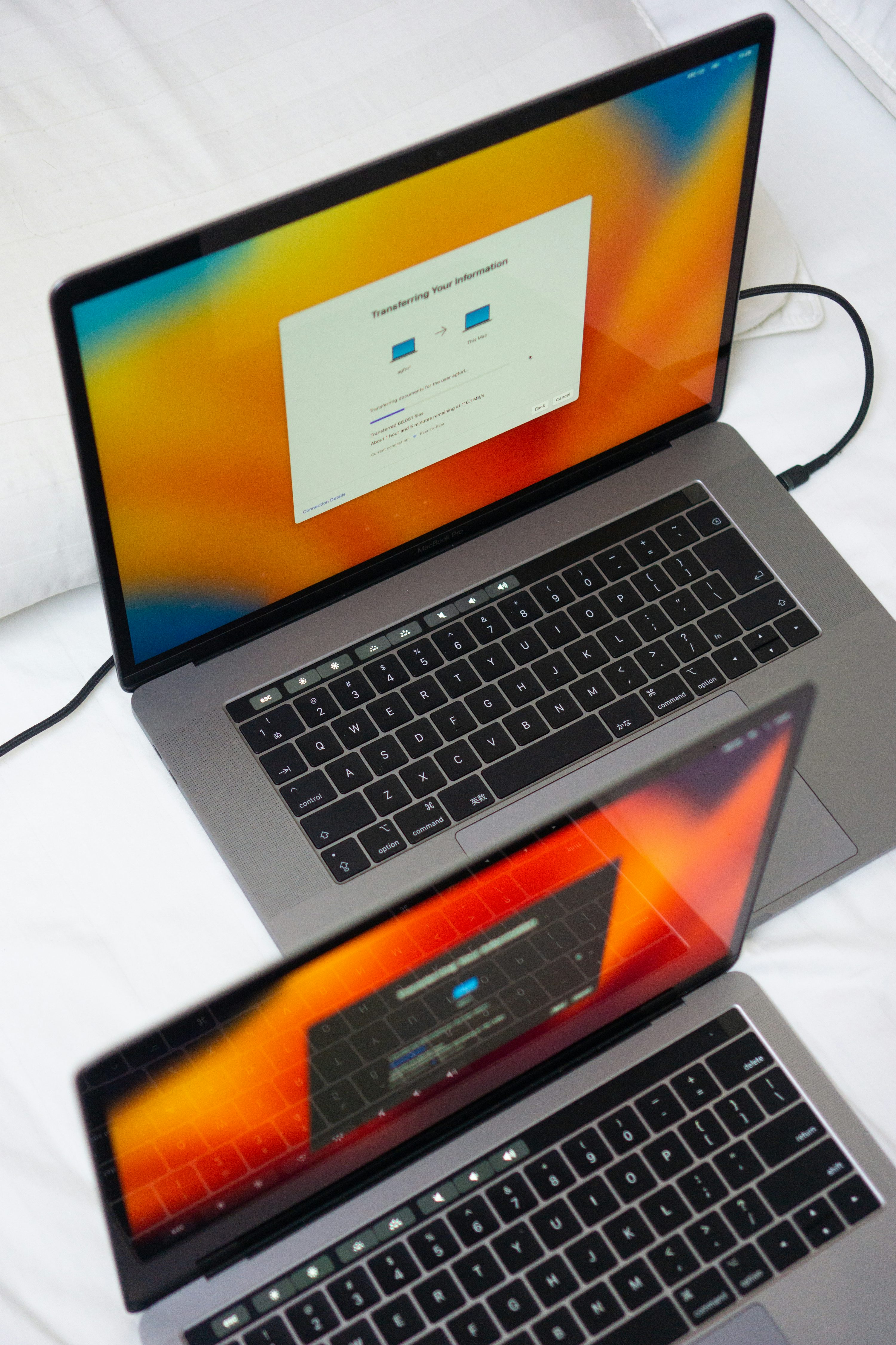 Un par de computadoras portátiles encima de una cama