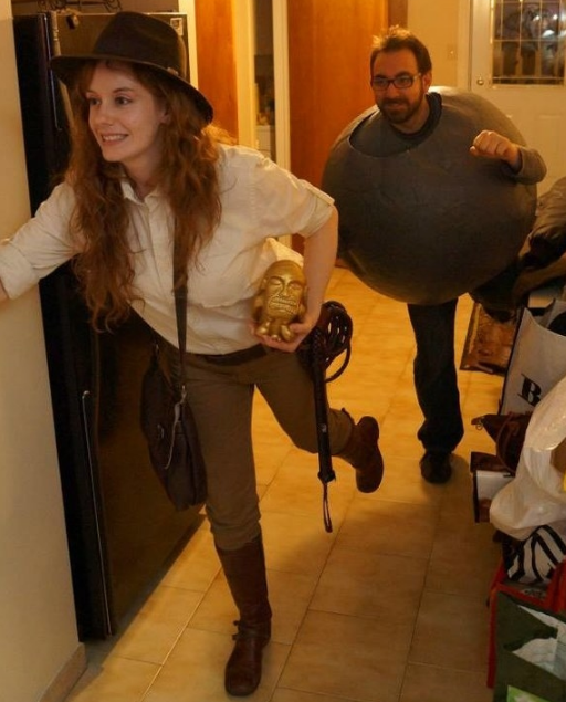 One person in a hat and button down shirt and one person dressed as a big boulder