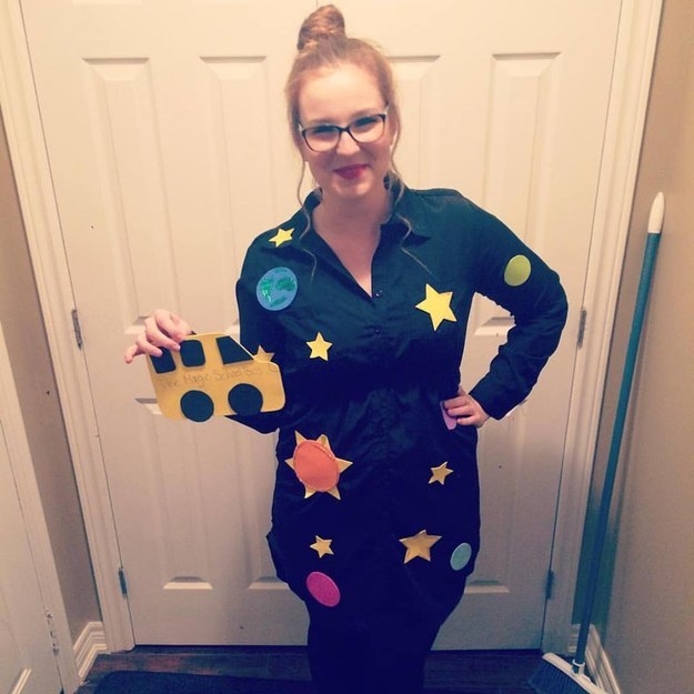 woman in a dress with stars on it holding a small school bus