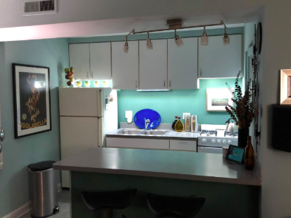 kitchen with plain white stock cabinets with lights underneath them to make it look so much better