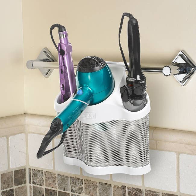 The styling station holding hair tools and hanging from a towel rack