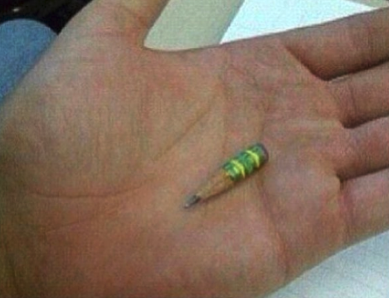 A small, heavily-used pencil stub rests in the palm of a person&#x27;s hand