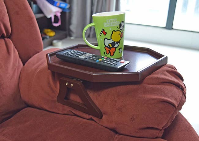 table surface clipped onto an arm of a couch. 