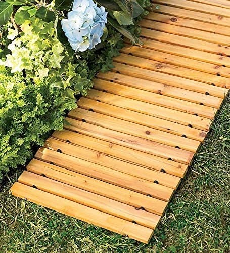 slotted wood walkway beside a bed of hydrangeas