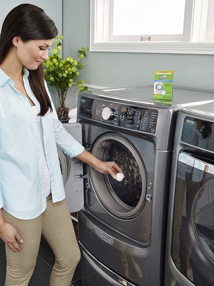 Model putting a washing machine tablet into their washing machine