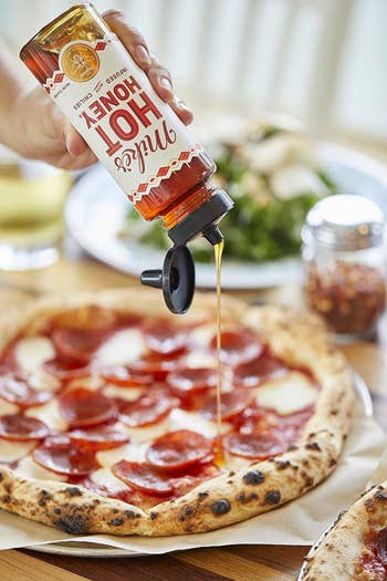 A bottle of the honey drizzled on pizza 