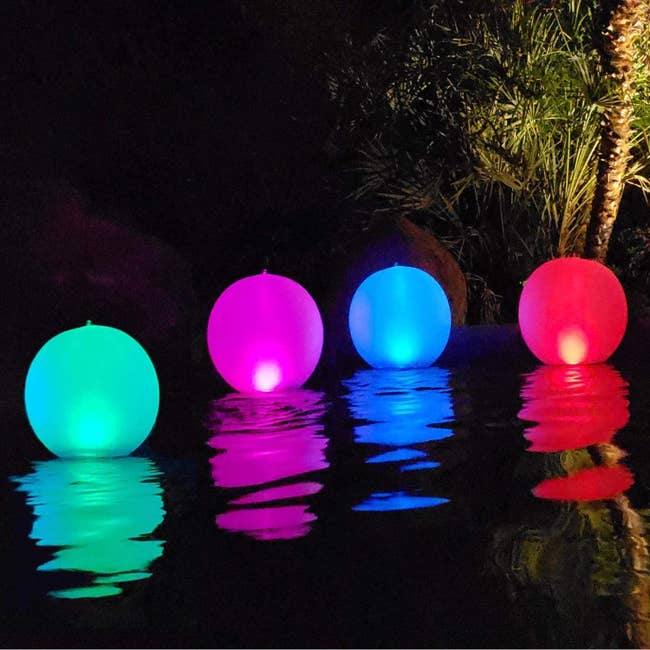 Four different-colored balls floating in the pool