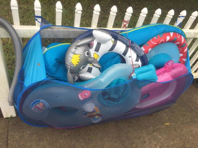 Reviewer photo of the organizer tied to their fence holding several large inflatables