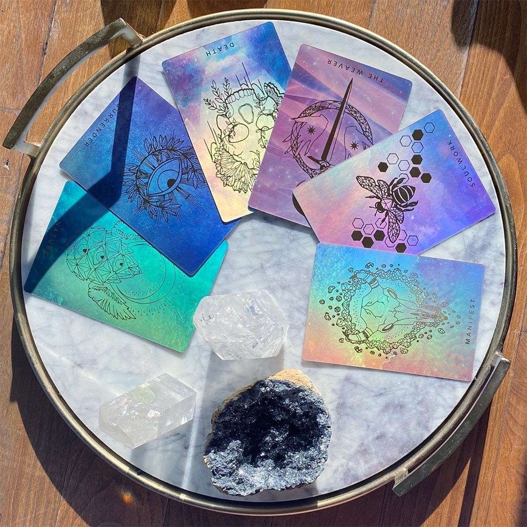 beautiful plastic iridescent cards on a marble platter with crystals