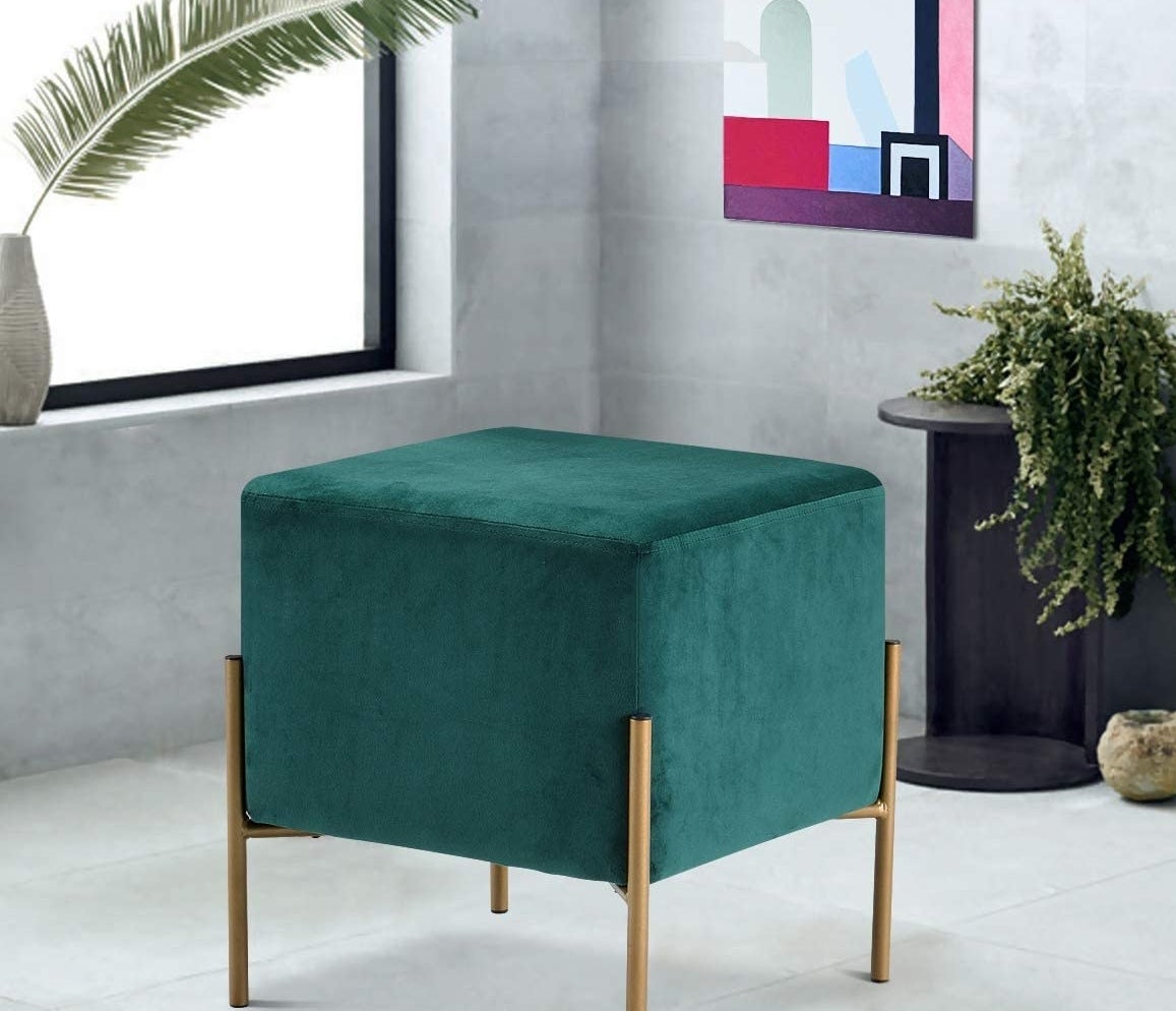 A square-shaped ottoman that fits into sleek gold leg frames