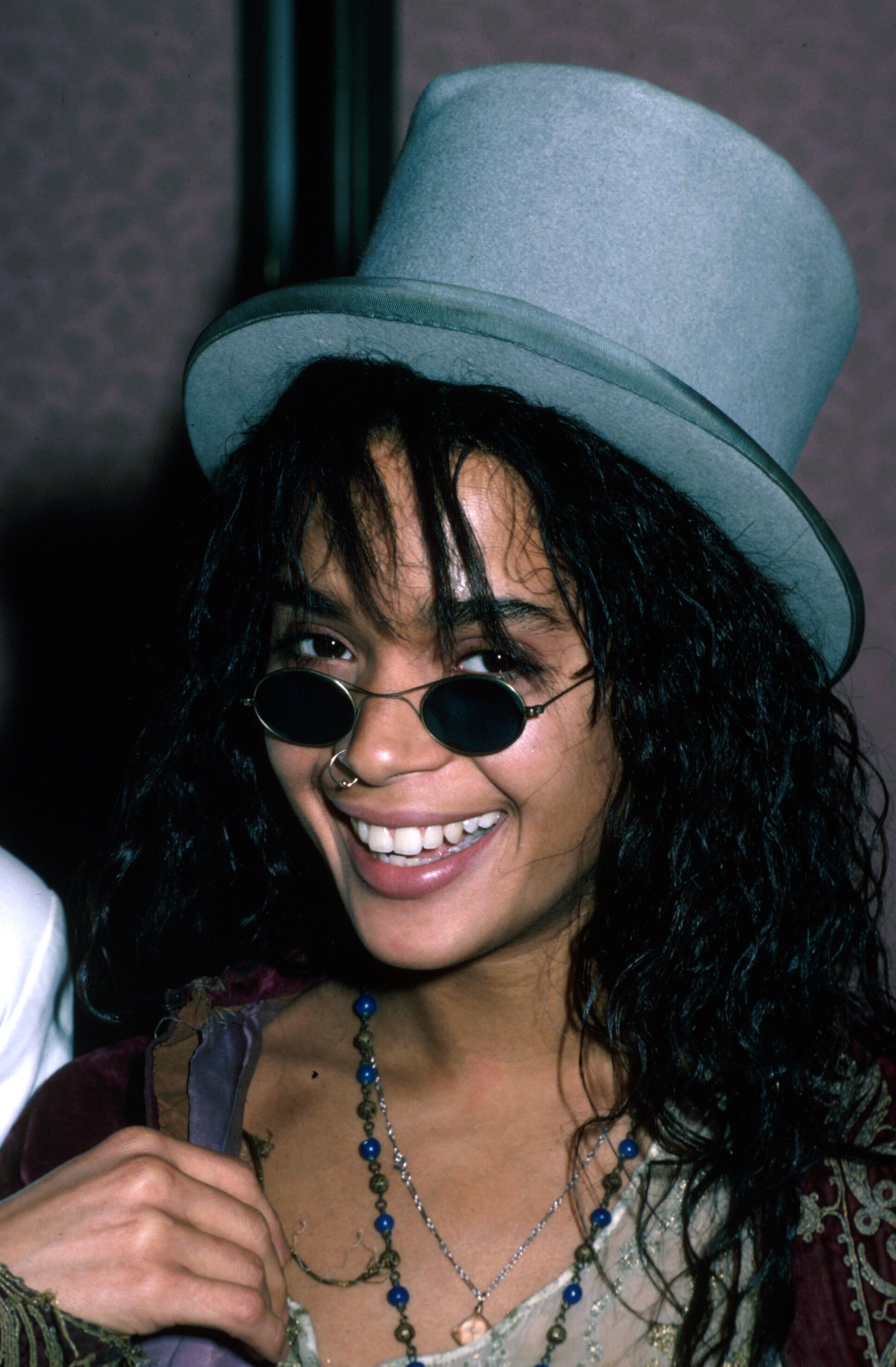 Lisa Bonet smiling, wearing a top hat and sunglasses