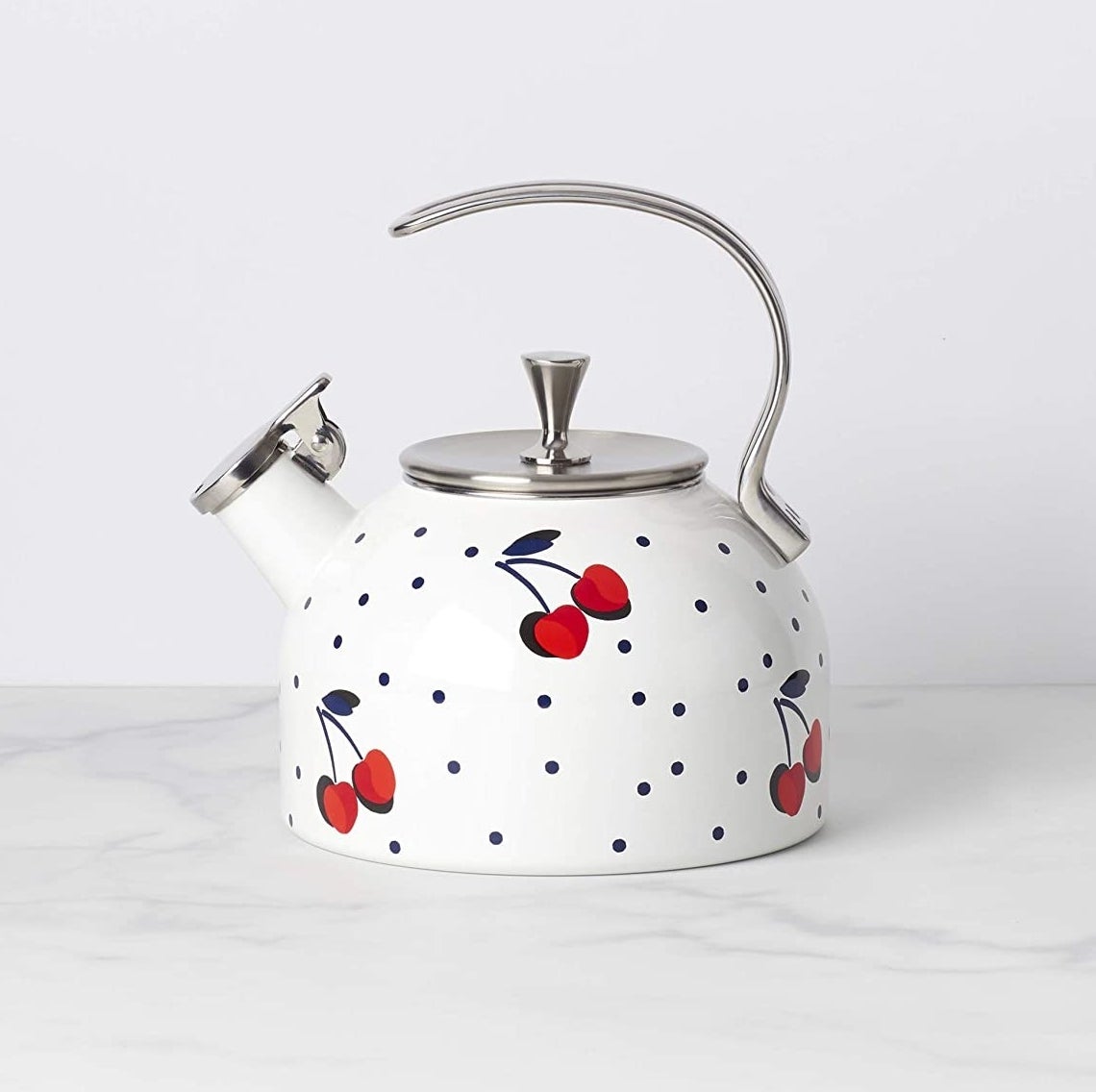 The polka-dotted white kettle which has a cherry pattern